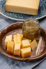 Cheese tasting, small pieces of old Dutch hard cheese and bowl with homemade dill-mustard sauce