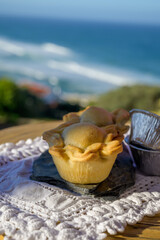 Portugeese food, oven baked chicken pie empada de frango, served outdoor with view on blue Atlantic ocean near Sintra in Lisbon area, Portugal