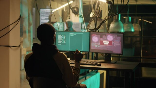 Happy thief successfully breaking network system on computer, doing hacking, cyberwarfare and espionage work at night. Criminal being congratulated about cryptojacking achievement.