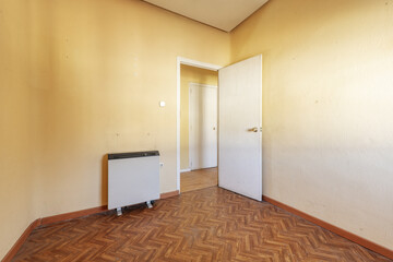 Empty room with ugly wood-like sintasol floor with electric heat accumulator