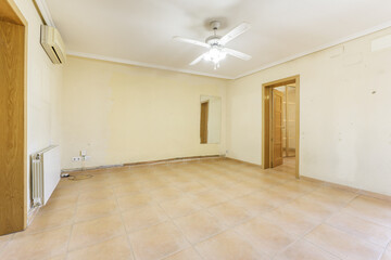 Empty room with brown stoneware floor, white aluminum radiator, mirror attached to the wall and...
