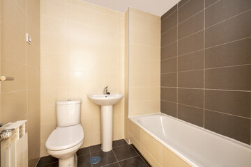 New bathroom without mirrors without partitions installed with white porcelain toilets and gray and cream tile and black floor