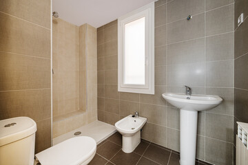 New bathroom without mirror without screens installed with white porcelain toilets and matching gray and beige tiles