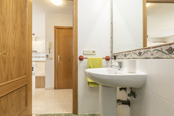 Bathroom with one-piece white porcelain pedestal sink and wall-mounted mirror with valance frame