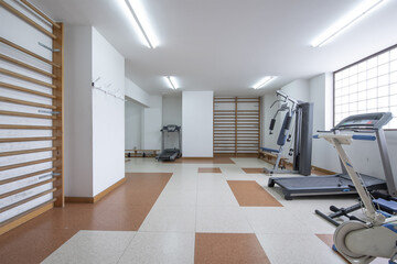 A community gym located in a room on the ground floor of a building with equipment and weights