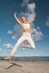 Fototapeta premium young athletic woman jumping and running on the beach