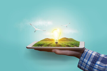 Abstract innovation tablet hand in hand with futuristic light bulb technology. Agriculture...