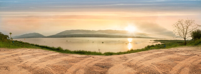 Empty dry cracked swamp reclamation soil, land plot for housing construction project with car tire print in rural area and beautiful blue sky with fresh air Land for sales landscape concept