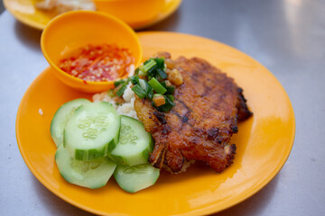 Com Tam - Closeup of vietnamese food: Delicious broken rice with egg pie and BBQ pork chop. fried egg meatloaf and pickles steak grilled pork ribs cucumber onion oil sweet chilies garlic fish sauce