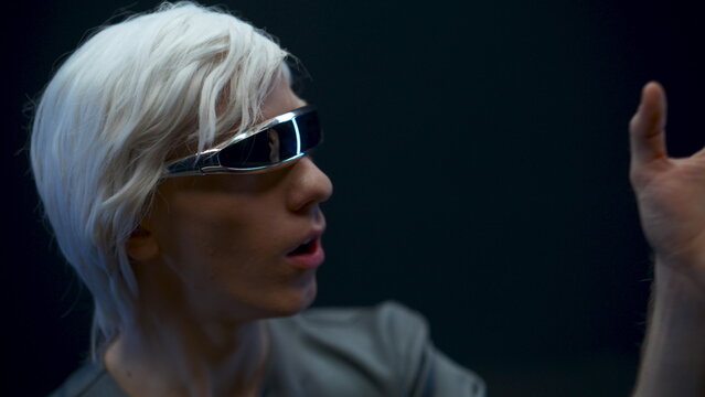 Amazed VR helmet man expressing wow reaction. Gamer touching invisible objects