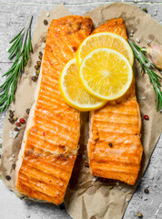 Grilled salmon fillet with slices of fresh lemon.