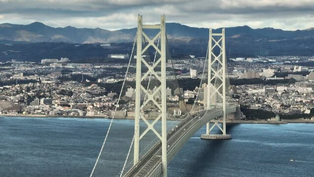 Light Traffic on Akashi Kaikyo Suspension Bridge with Coastal City and Mountains