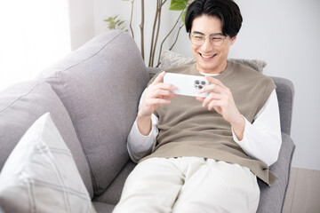 リビング(部屋)で動画を見て楽しむ男性　