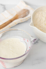 Buttermilk in Measuring Cup with Biscuit Ingredients in Background