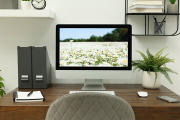 Cozy workspace with computer on wooden desk at home