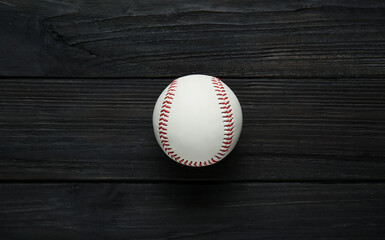 Baseball ball on black wooden table, top view. Sports game