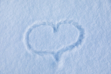 Heart drawn on snow, top view. Winter season