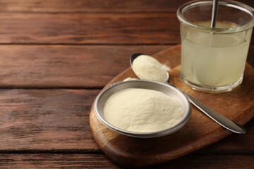 Glass of agar-agar jelly and powder on wooden table. Space for text