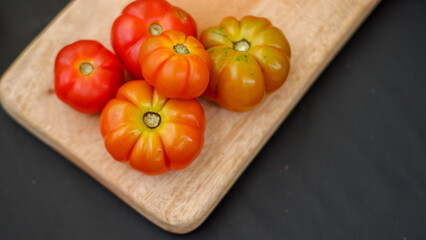heap of heirloom or hillbilly tomato isolated on black background.
