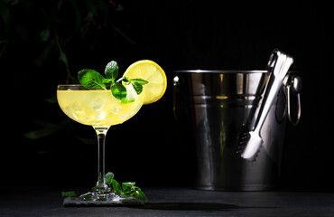 White lady alcoholic cocktail with dry gin, liquor, lemon juice and ice in glass. Black background