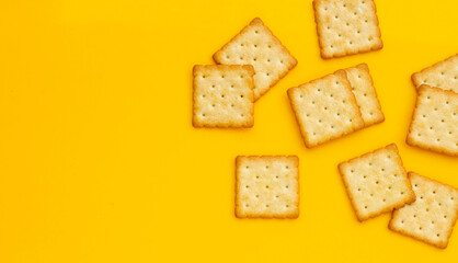 Dry cracker cookies on yellow background.