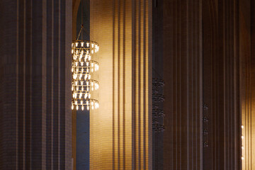 Dark atmosphere and selective detail of lamp chandelier, cream brick vault, arch, rib wall, column...