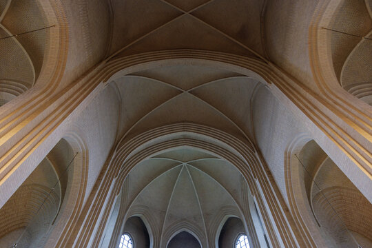Detail of cream brick vault, arch, rib wall, column and clerestory element on the ceiling of expressionist protestant church in Copenhagen, Denmark. 