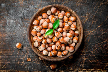 Hazelnuts with leaves in a bowl.