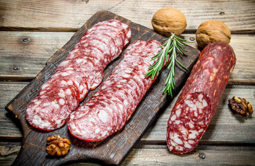 Sliced salami with rosemary and walnuts.