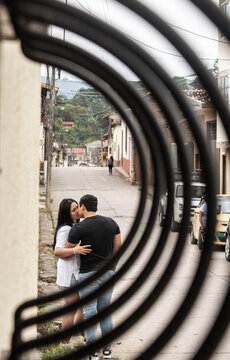 Pareja de jóvenes enamorados besándose en la calle de un pueblo colonial - Charalá, Santader, Colombia