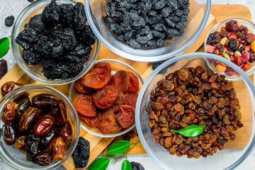 Assortment of different types of dried fruits in bowls.