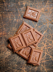 Chocolate wedges on wooden background.