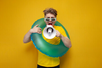 young guy on vacation in the summer shouts and announces the news in a megaphone, man with an...