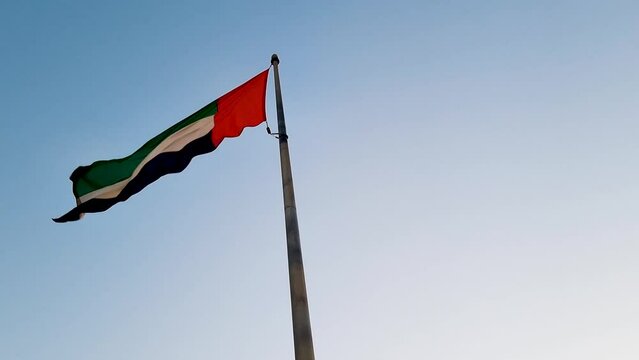 Footage of the UAE national flag on the pole outdoors. Country