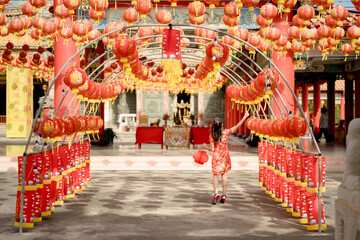 Beautiful young asian woman wearing traditional cheongsam qipao dress holding lantern and walking...