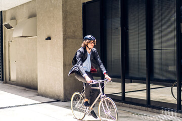 Portrait of hipster handsome businessman in suit with backpack looking forward while commuting riding bicycle on the street city way go to work.business travel transport bike concept.