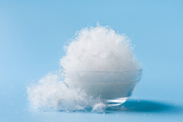  white down feathers on blue background.