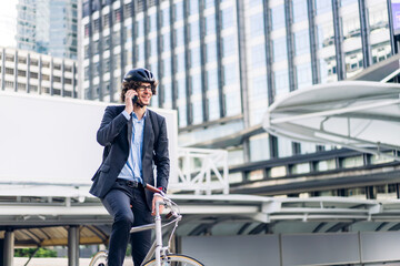 Portrait of casual hipster handsome businessman with backpack talk on smartphone while commuting riding bicycle on the street city way go to work.business travel transport bike concept.
