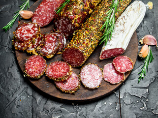 Assortment of different salami with spices and herbs.