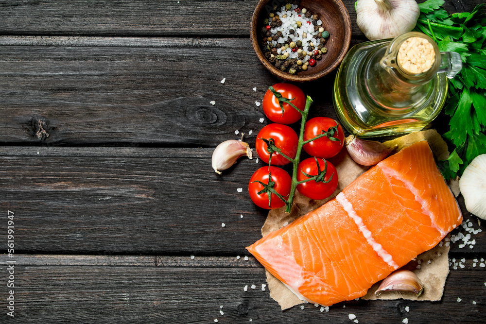 Poster raw salmon fish steaks with garlic and tomatoes.