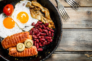 English breakfast.Fried eggs with sausages, mushrooms and beans.