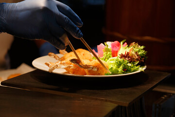 professional chef cooking and using chopsticks to decorating delicious dish for special dinner meal in the restaurant. food and cooking concept.