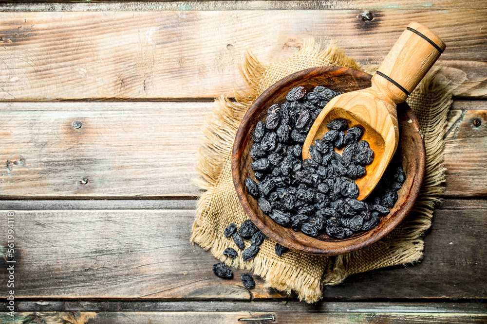 Wall mural raisins in a bowl with a wooden scoop.