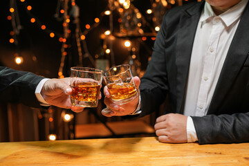 food and drink male friends are happy drinking beer and clinking glasses at a bar or pub.