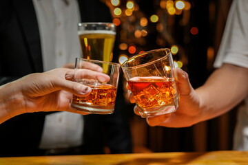 food and drink male friends are happy drinking beer and clinking glasses at a bar or pub.