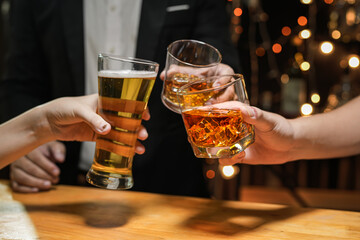 food and drink male friends are happy drinking beer and clinking glasses at a bar or pub.