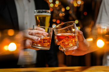 food and drink male friends are happy drinking beer and clinking glasses at a bar or pub.