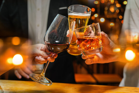 food and drink male friends are happy drinking beer and clinking glasses at a bar or pub.