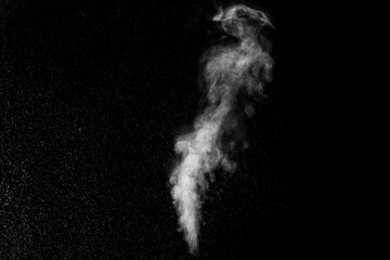 A jet of white water vapor with splashes of water from the humidifier Isolated on a black...