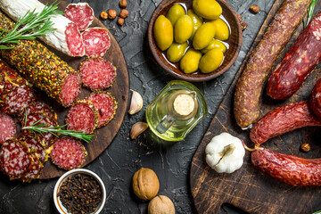 Variety of smoked salami with olives, herbs and spices.